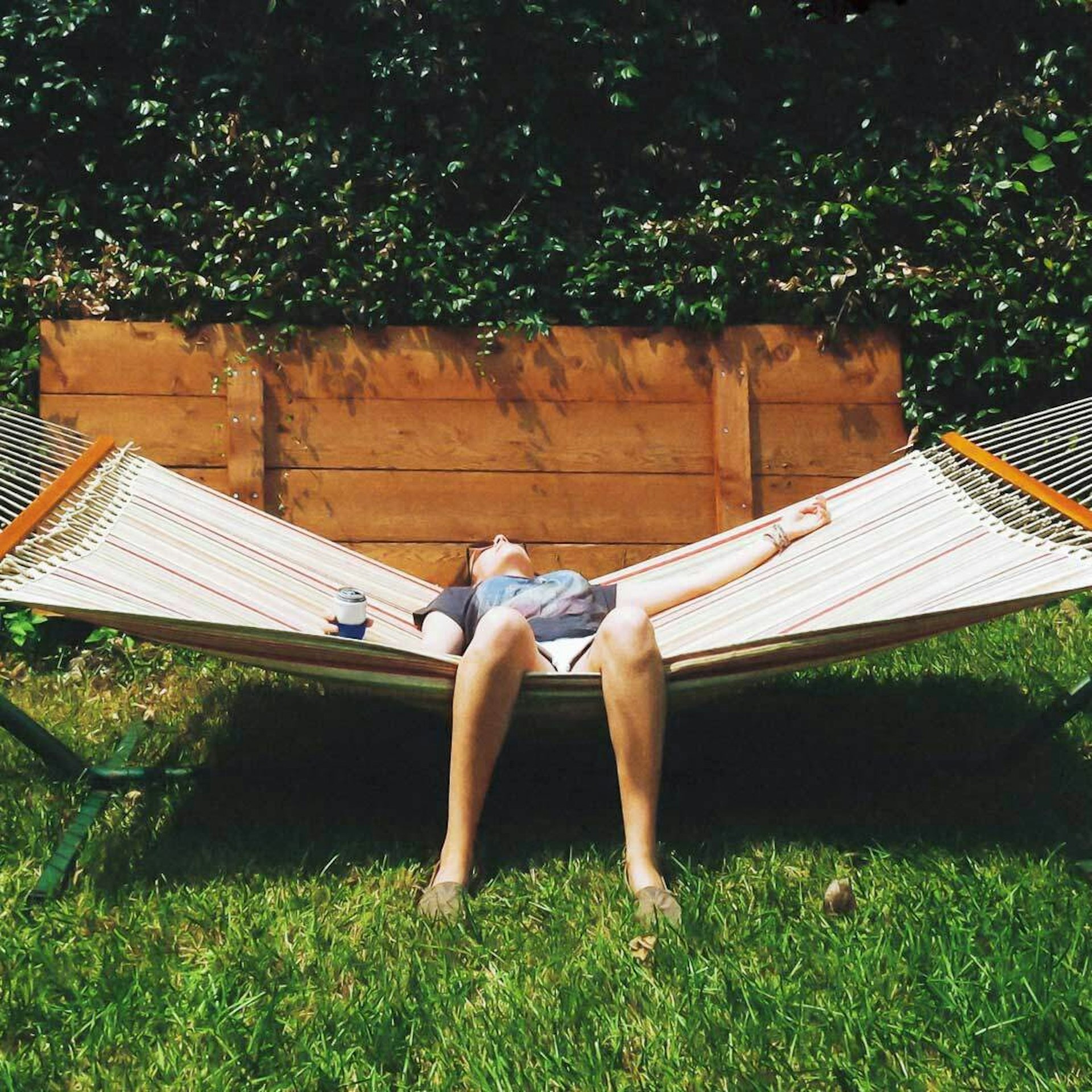 A person lies back on a hammock.