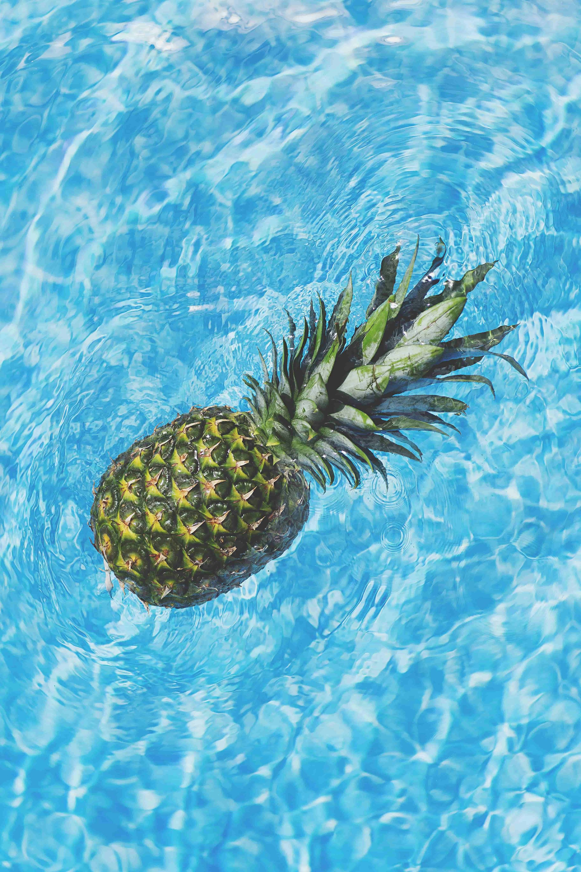 A pineapple floating in water.