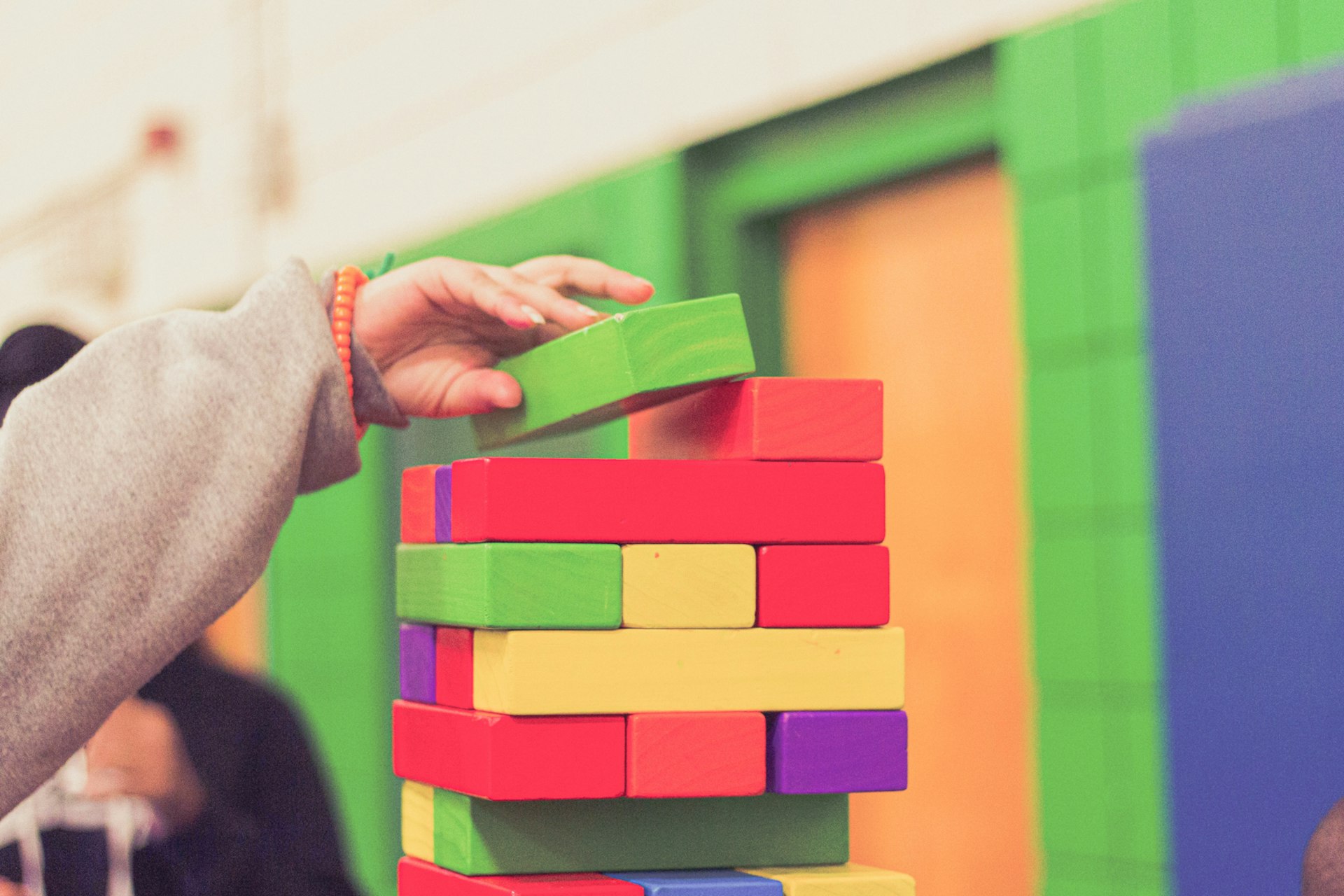 A child building a tower of coloured blocks