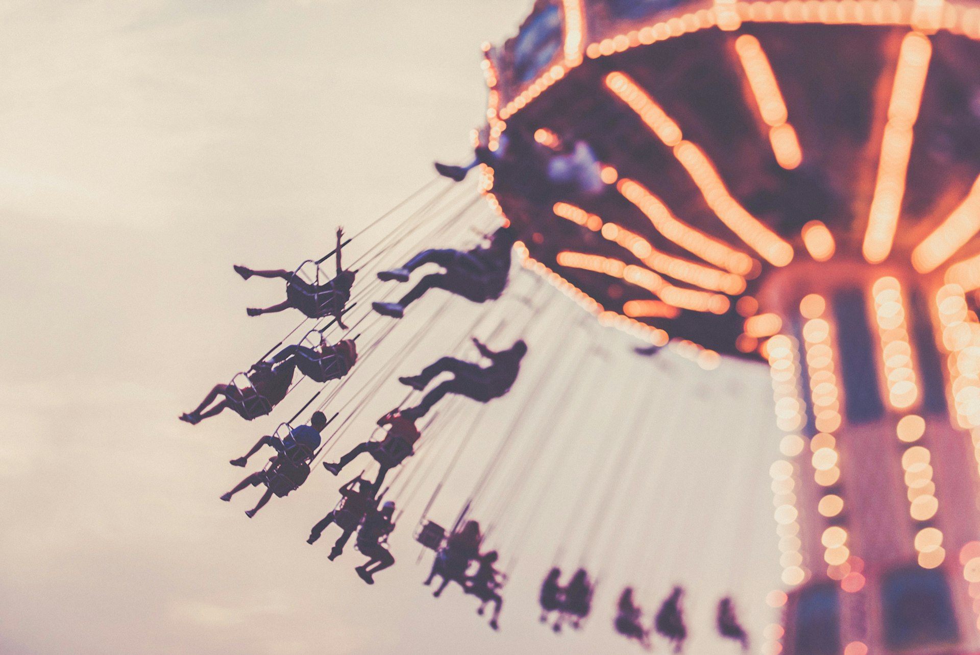 People hanging from a fairground ride.