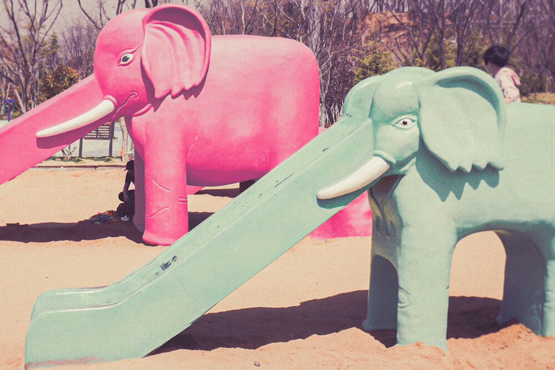 Playground equipment shaped like elephants with slides for trunks. 