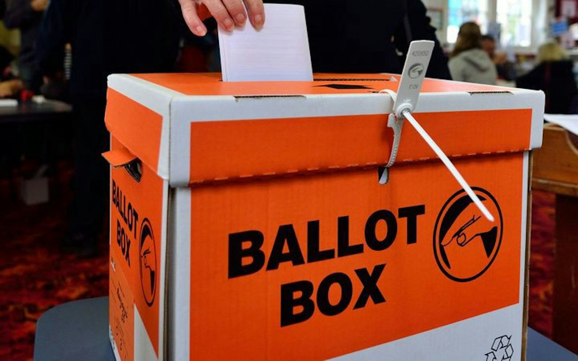 Photo of someone dropping a voting card into an NZ Election ballot box.